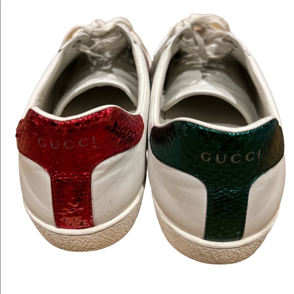 Off white colored low top sneakers by Gucci